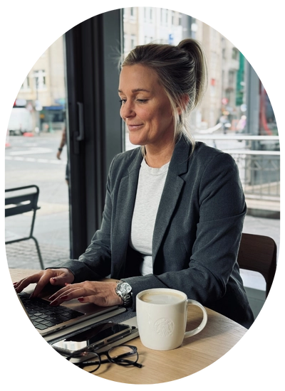 ImmoBlog in Bergisch Gladbach, Tanja Polly - RS Immobilieninvest, am Laptop mit Kaffeetasse